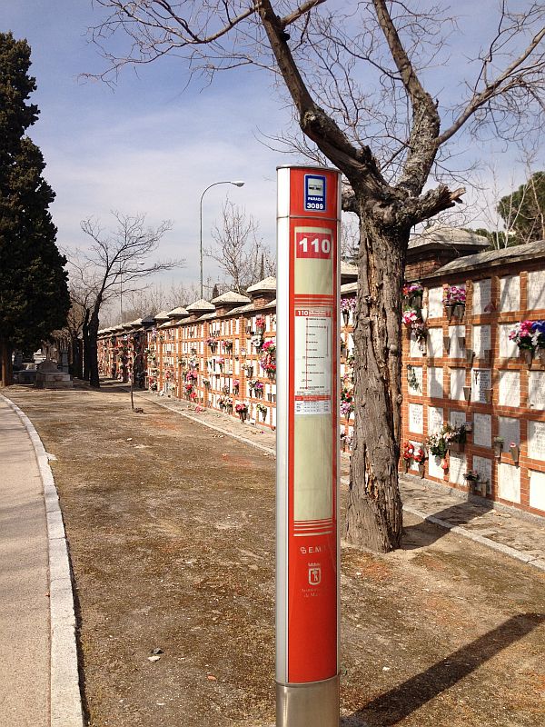 Bushaltestelle zwischen Gräbern. Da der Friedhof so weitläufig ist, gibt es eine Buslinie und zwei Metro-Stationen.